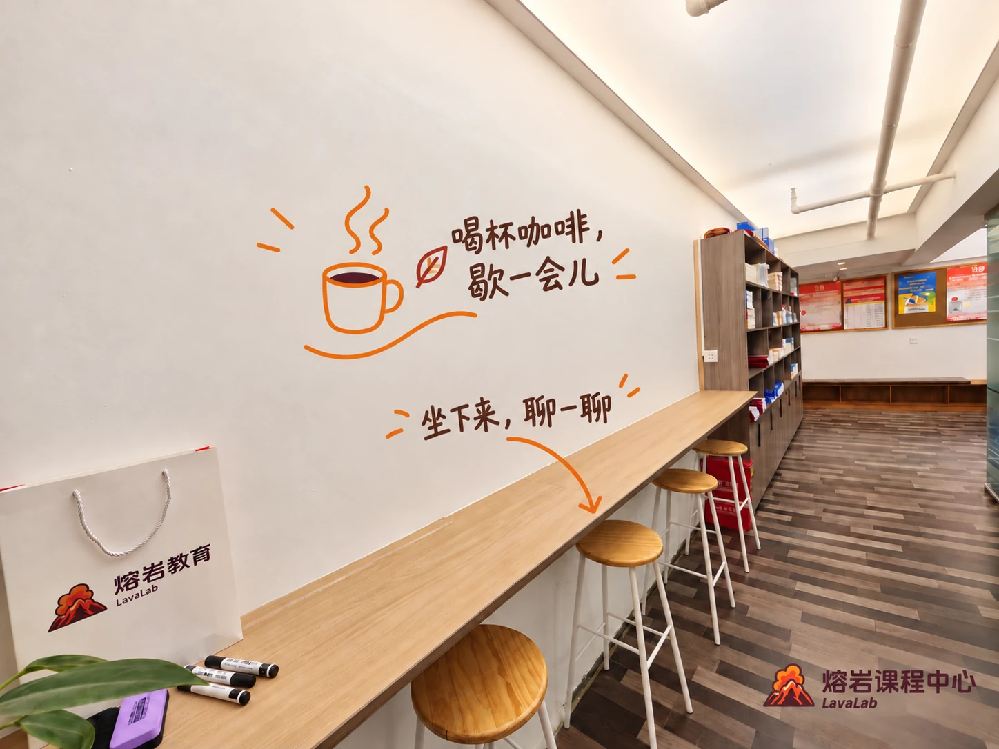 熔岩课程中心休息区实景，木质吧台与座椅，配有手绘咖啡标注